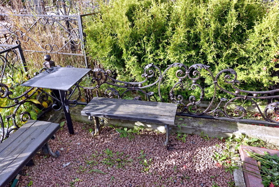 Красивая черная кованая ограда с лавочками и столиком