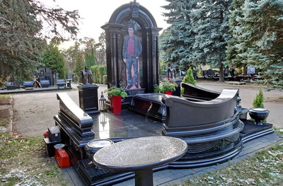 Резное гранитное надгробье в форме арки с ростовым портретом покойного